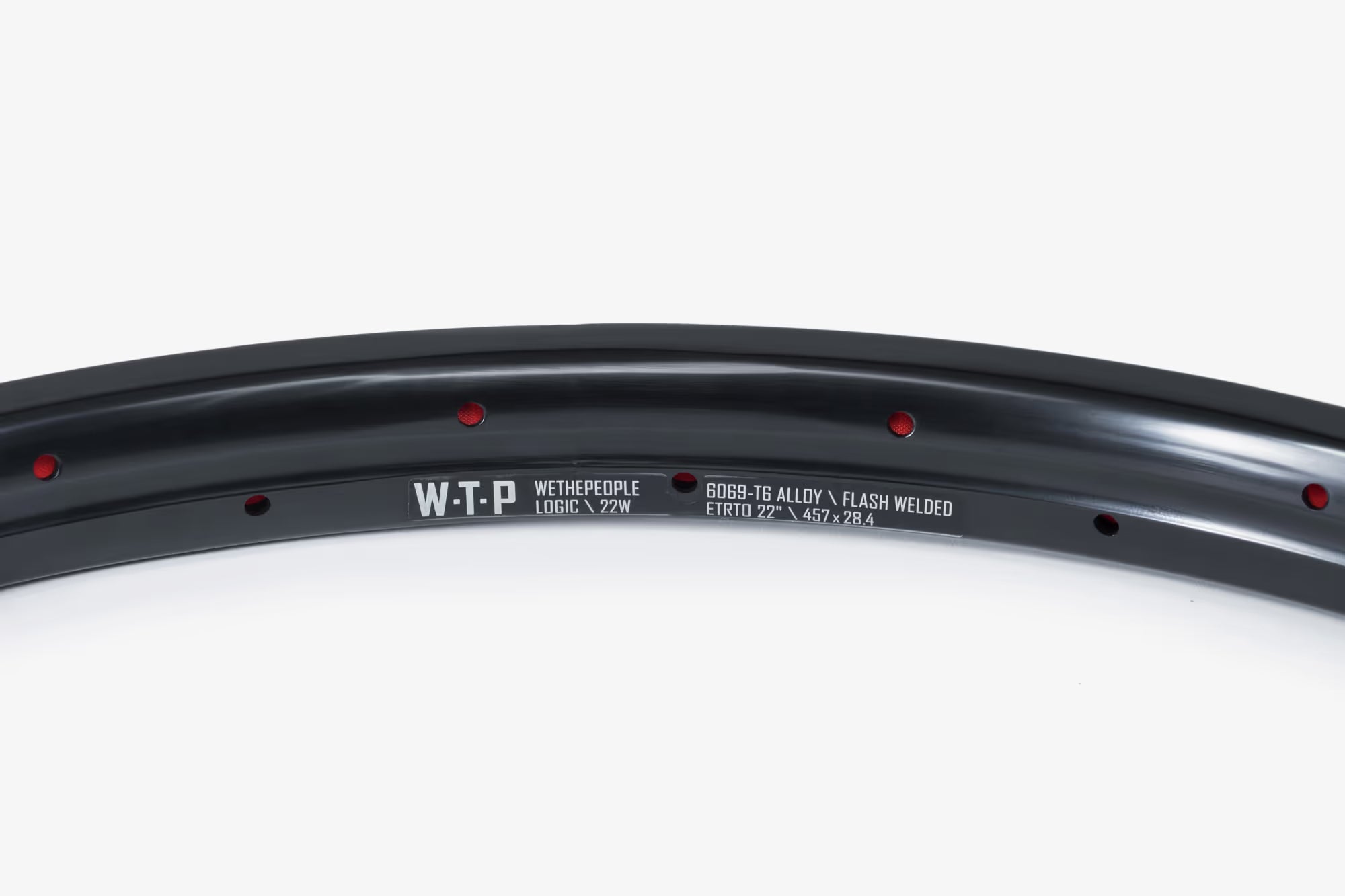 Close-up of a black WeThePeople Logic 22W BMX rim, featuring 6069-T6 alloy, flash welded construction, and ETRTO 22" 457 x 28.4 dimensions