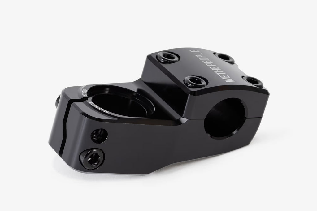 Black anodized aluminum bicycle stem shown from above, featuring WeThePeople branding, multiple hex bolt mounting points, and a hinged clamp design for handlebar attachmen