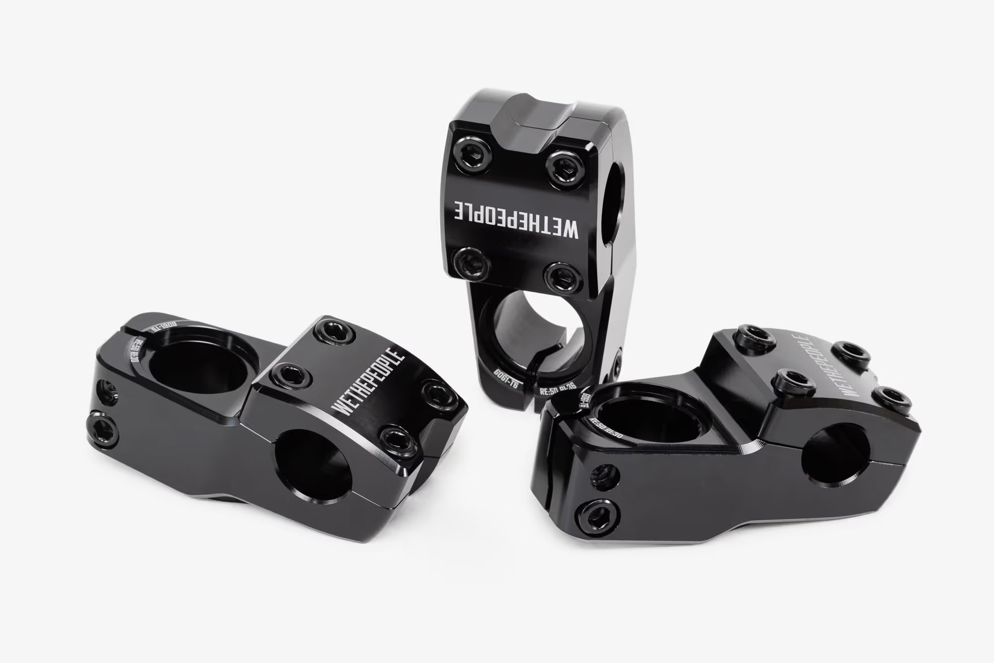 Side view of black bicycle stem with removable clamp components separated, showing the main stem body and detachable handlebar clamp with visible hex bolts and threaded hardware