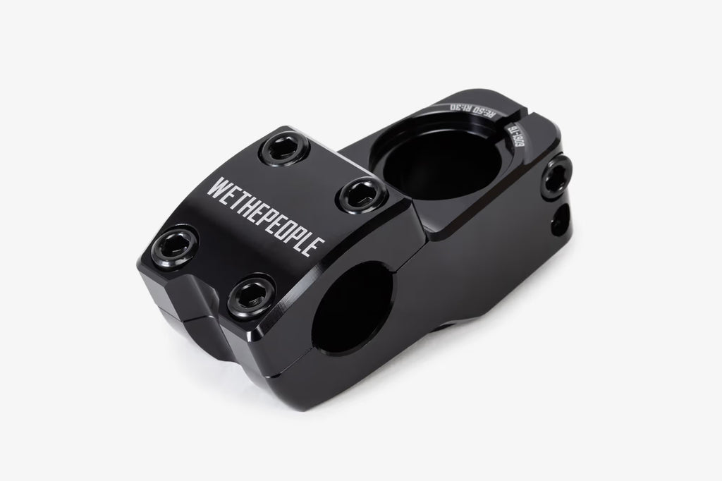 Black anodized aluminum bicycle stem shown from above, featuring WeThePeople branding, multiple hex bolt mounting points, and a hinged clamp design for handlebar attachmen