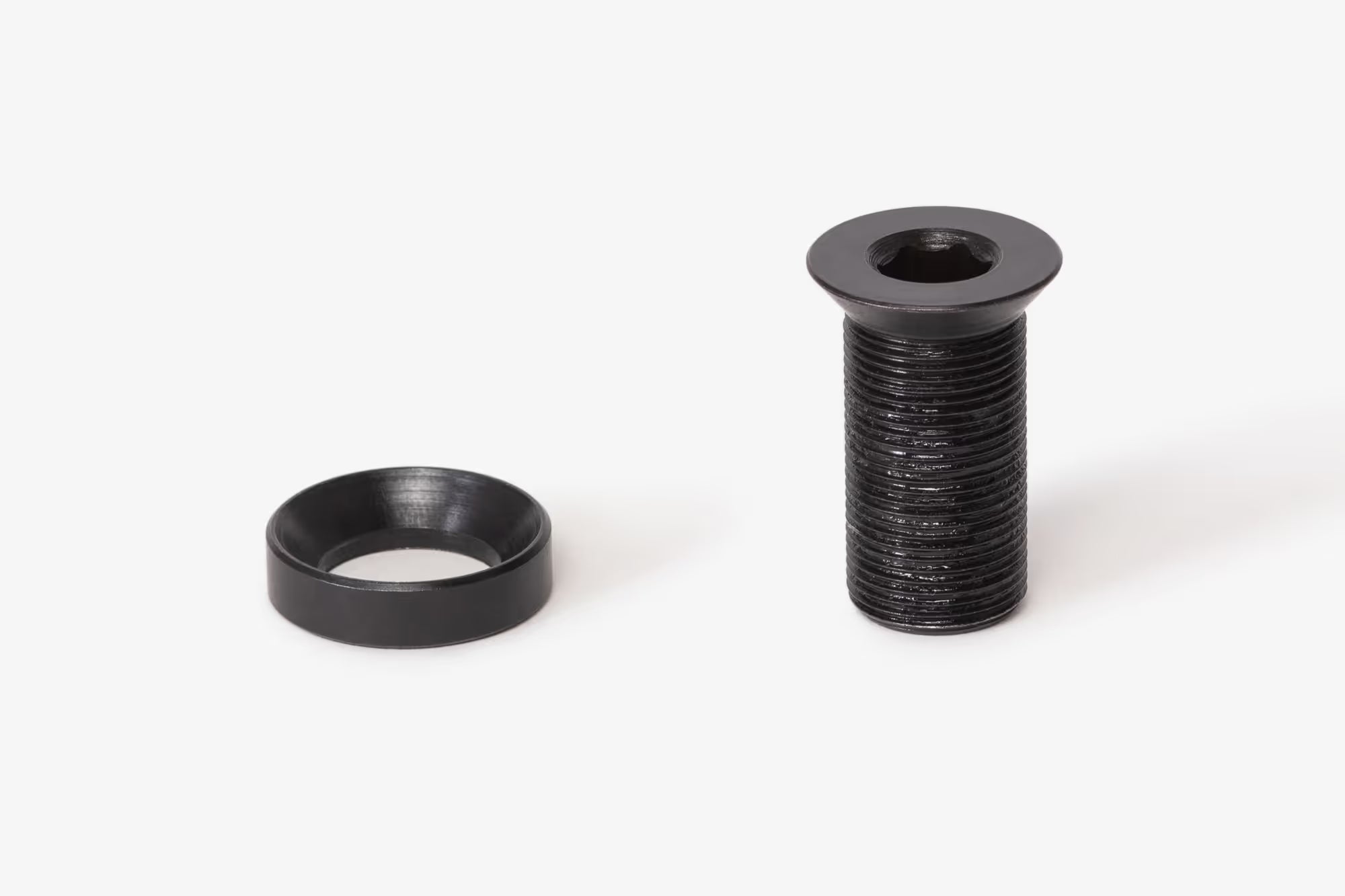 Black Eclat Tibia BMX crank bolt and conical washer set on a white background