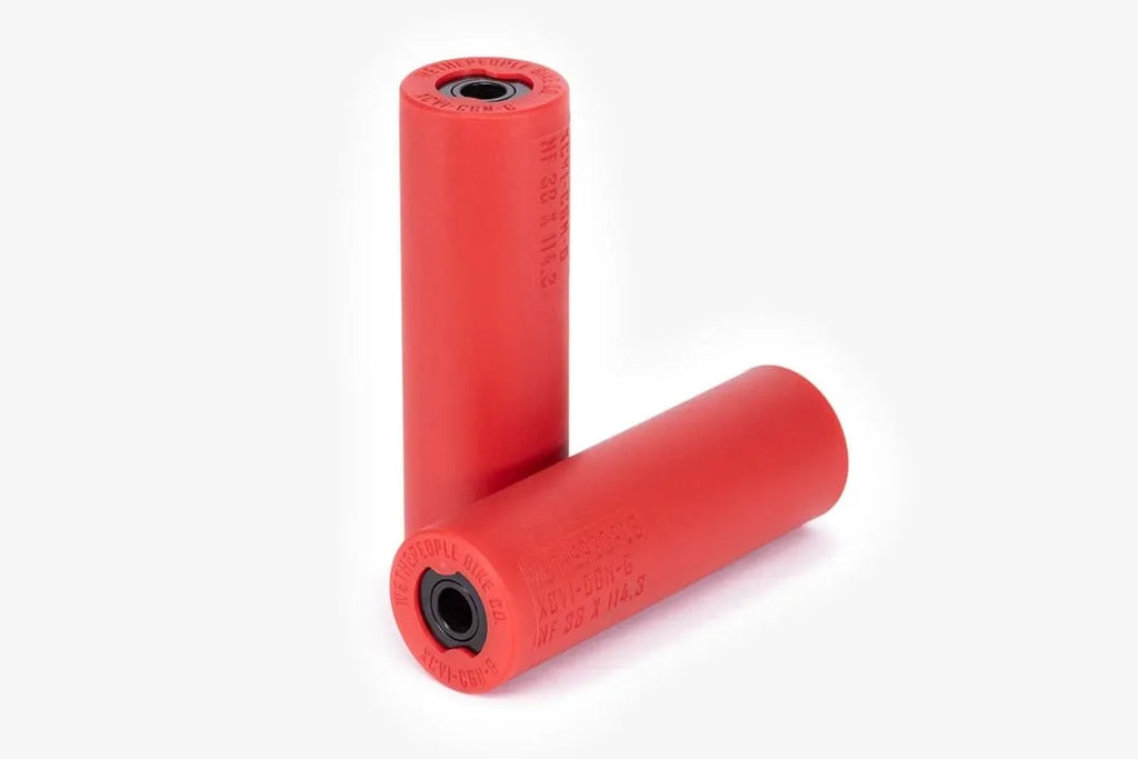 Pair of Wethepeople (WTP) Temper BMX Pegs, vibrant red color, showcasing the durable nylon sleeve and the detailed aluminum inner core end caps.
