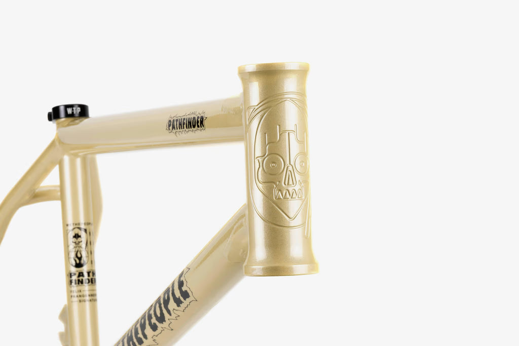 We The People Pathfinder BMX frame in cream soda color, featuring a detailed skull graphic on the head tube and 'PATHFINDER' branding along the top tube