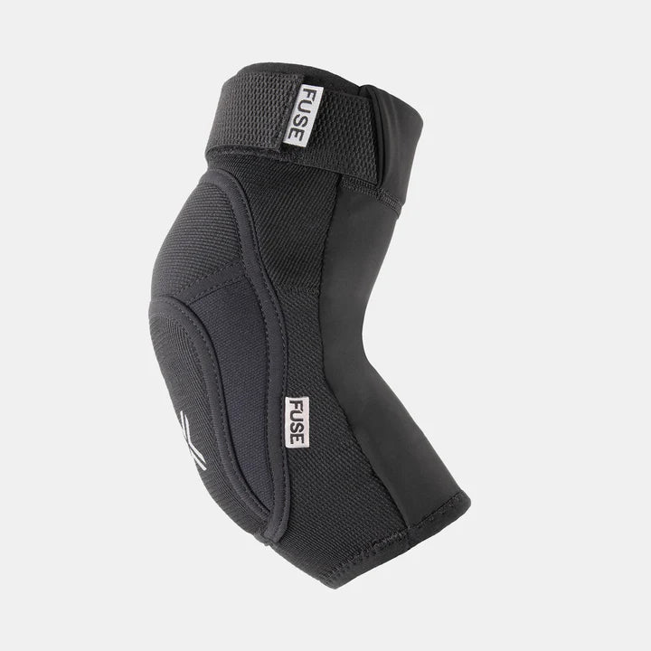 FUSE Alpha Classic Elbow Pad, black, angled view showing the ergonomic sleeve, adjustable top strap, and FUSE branding labels.