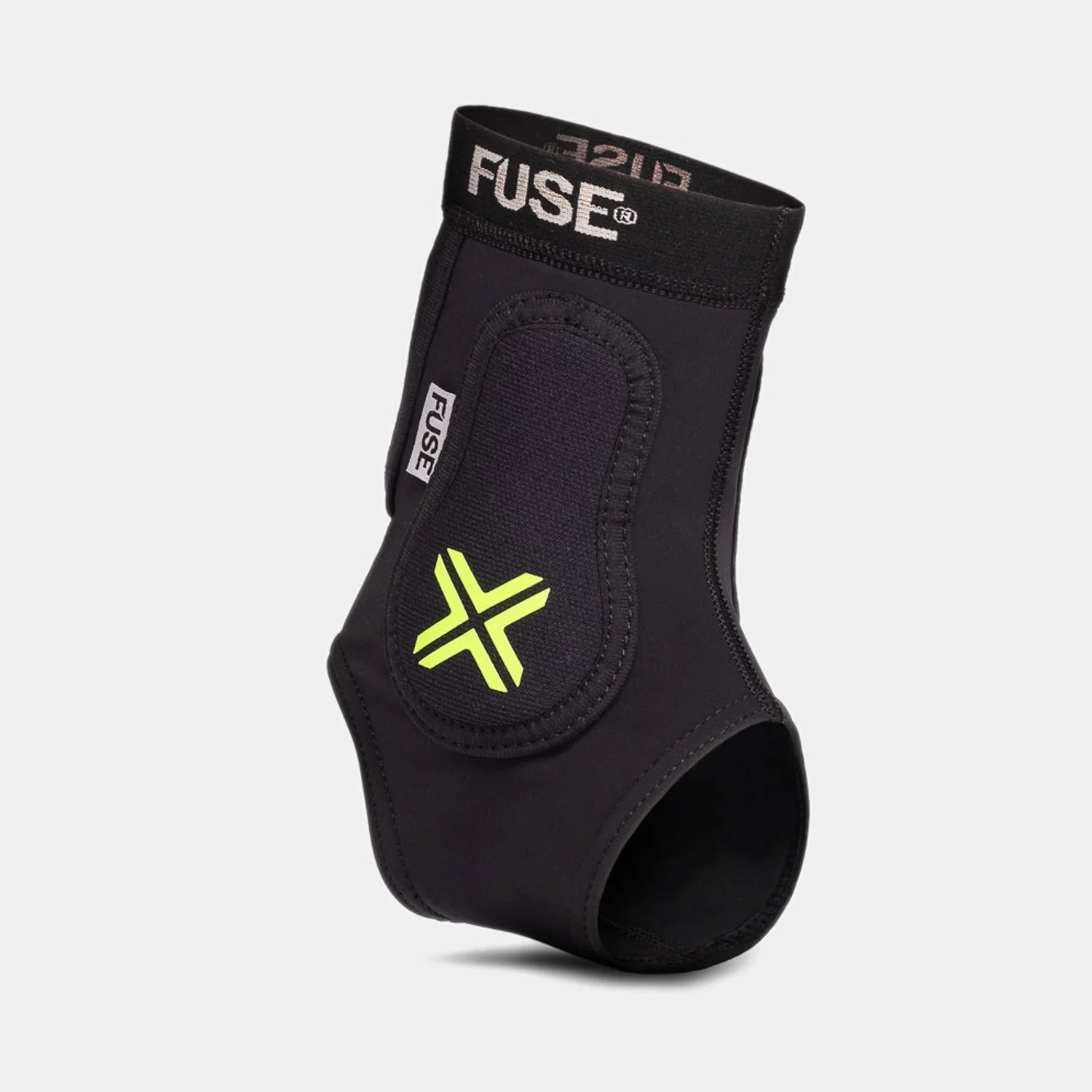 FUSE Omega Ankle Protector, black, angled view highlighting the yellow/neon 'X' logo on the protective padding and the elastic FUSE band.