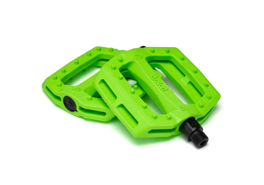 Two green bicycle pedals on a white background