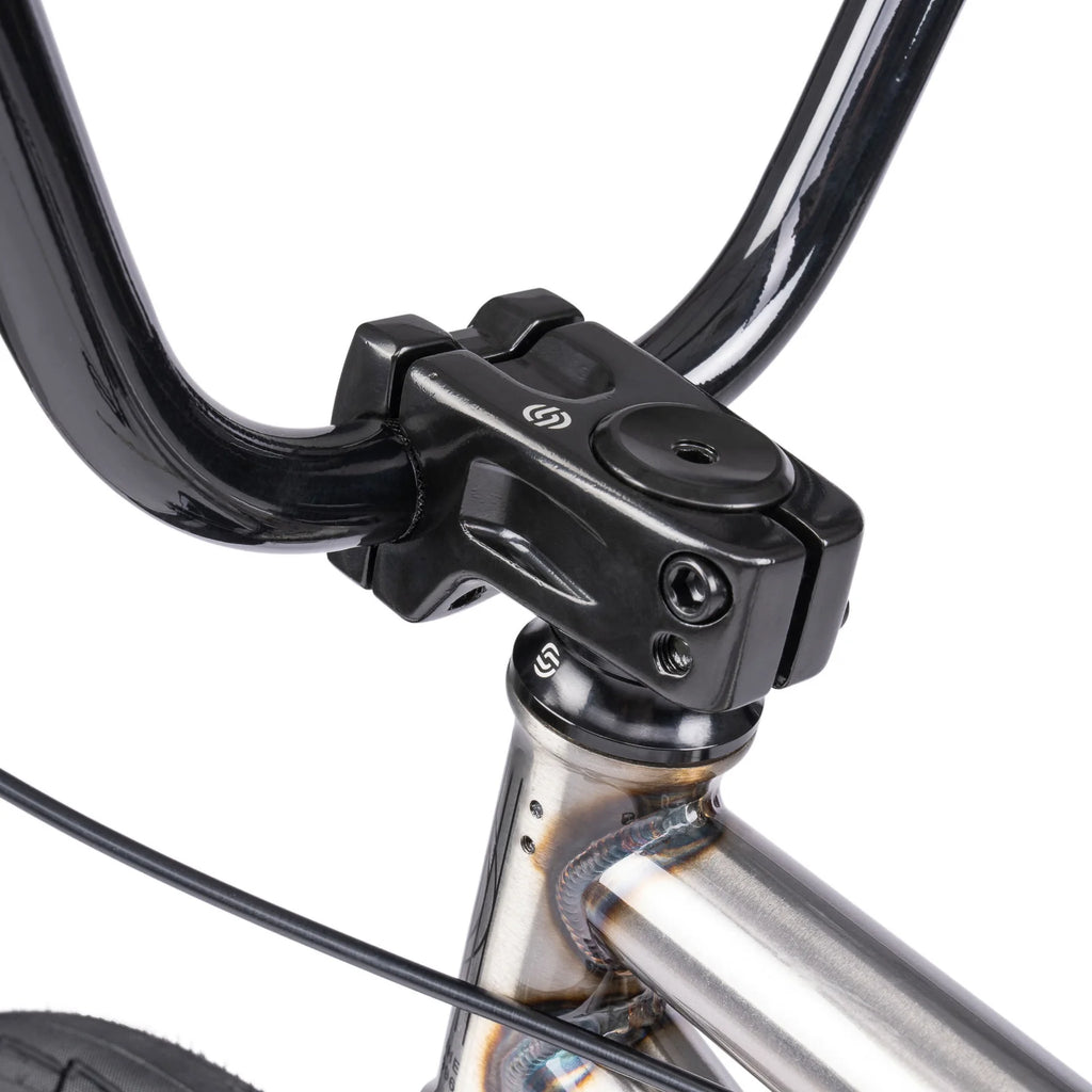 Close-up of a bicycle handlebar with black clamp and silver frame on a white background